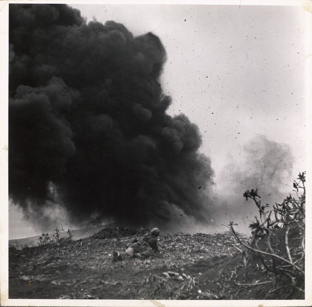 Marines in Iwo Jima: Lone marine lying on ground views demolition ...